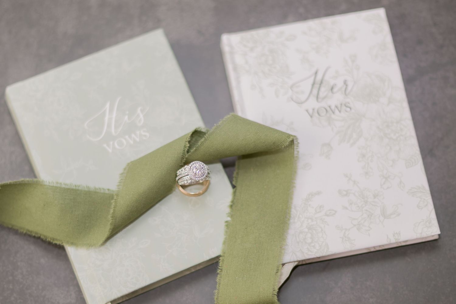 Wedding invitation suite featuring sage green ribbon and delicate details on white paper.