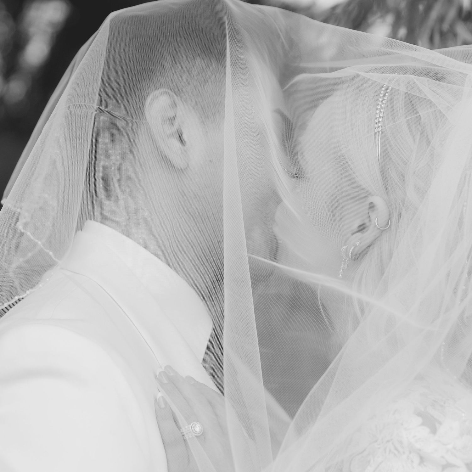 Close-up detail of delicate white wedding veil and lace in soft focus.