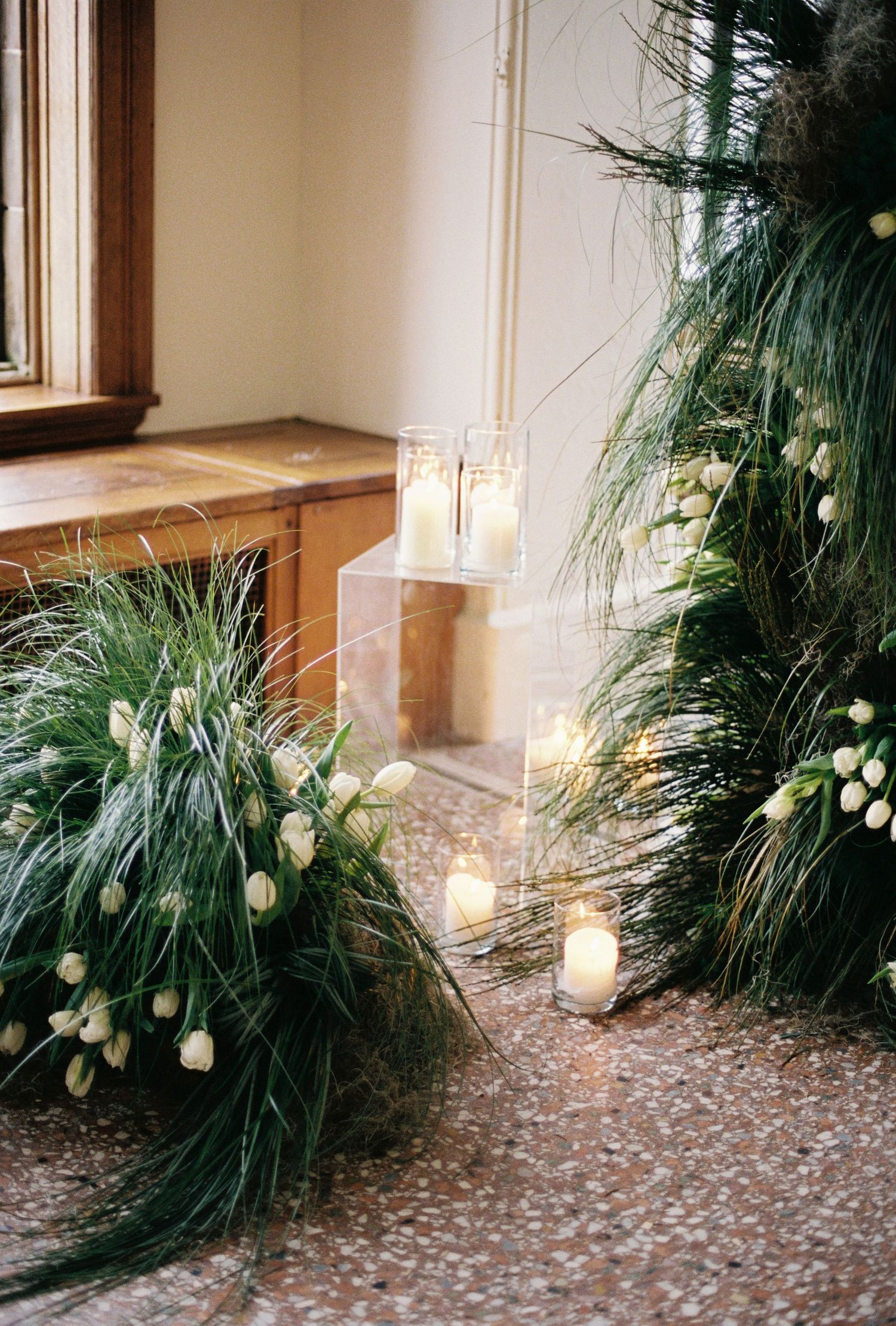 The image shows a bride in a white wedding dress posing on a staircase in a formal setting.