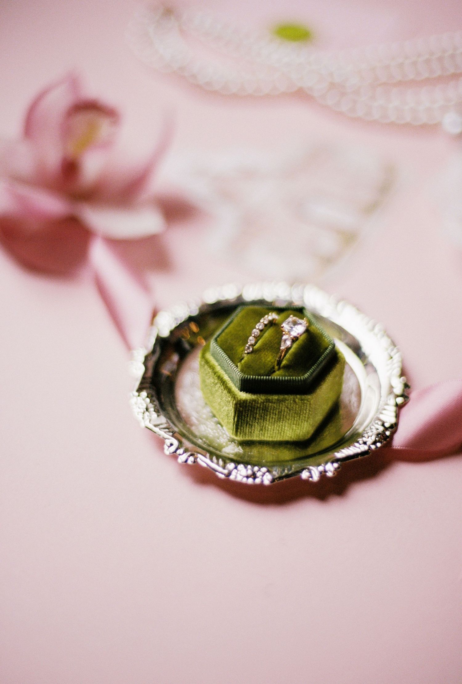 A close-up of a ring with a green gemstone set in a silver band.