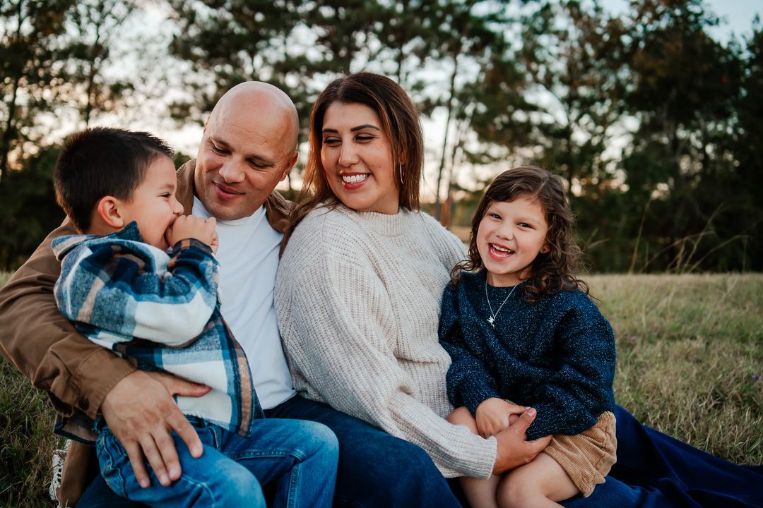 Family embracing and sharing joyful moment outdoors in natural setting.