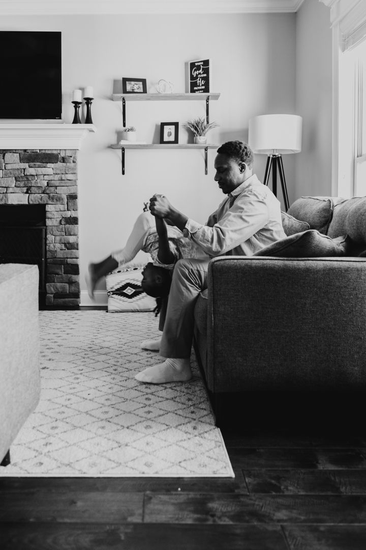Black and white sequence showing playful moments on a gray couch in living room.