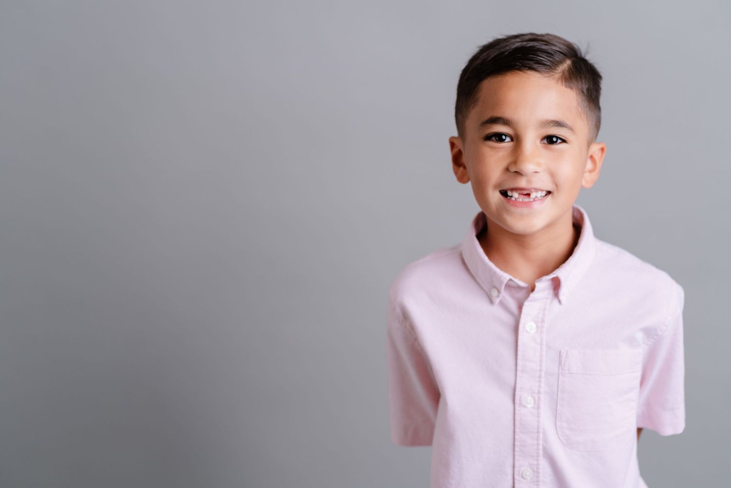 A series of casual portrait photos showing someone wearing a light colored shirt against a gray background.