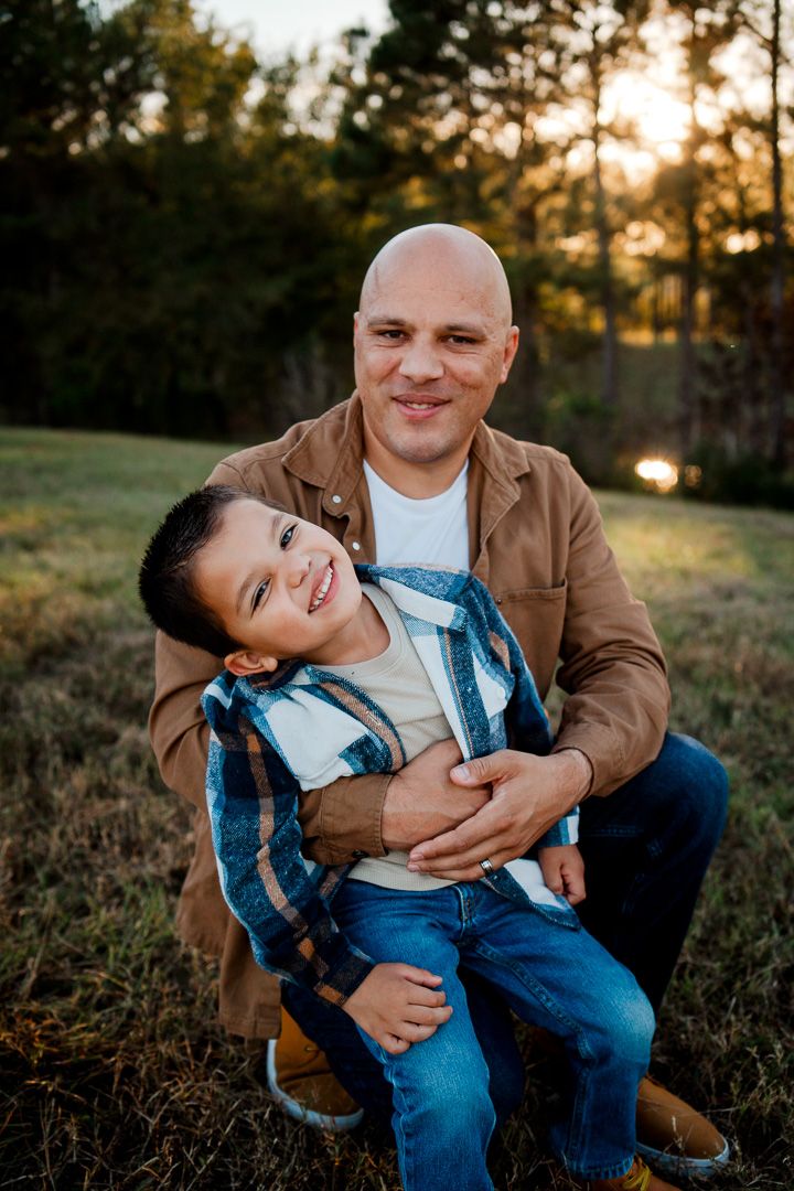 Playful father and child moments captured during sunset outdoor photo session.