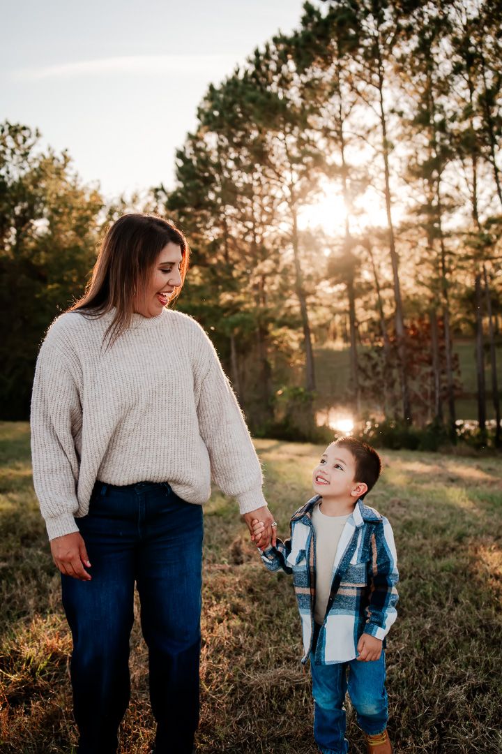 A heartwarming interaction between parent and child in a sunset-lit field.