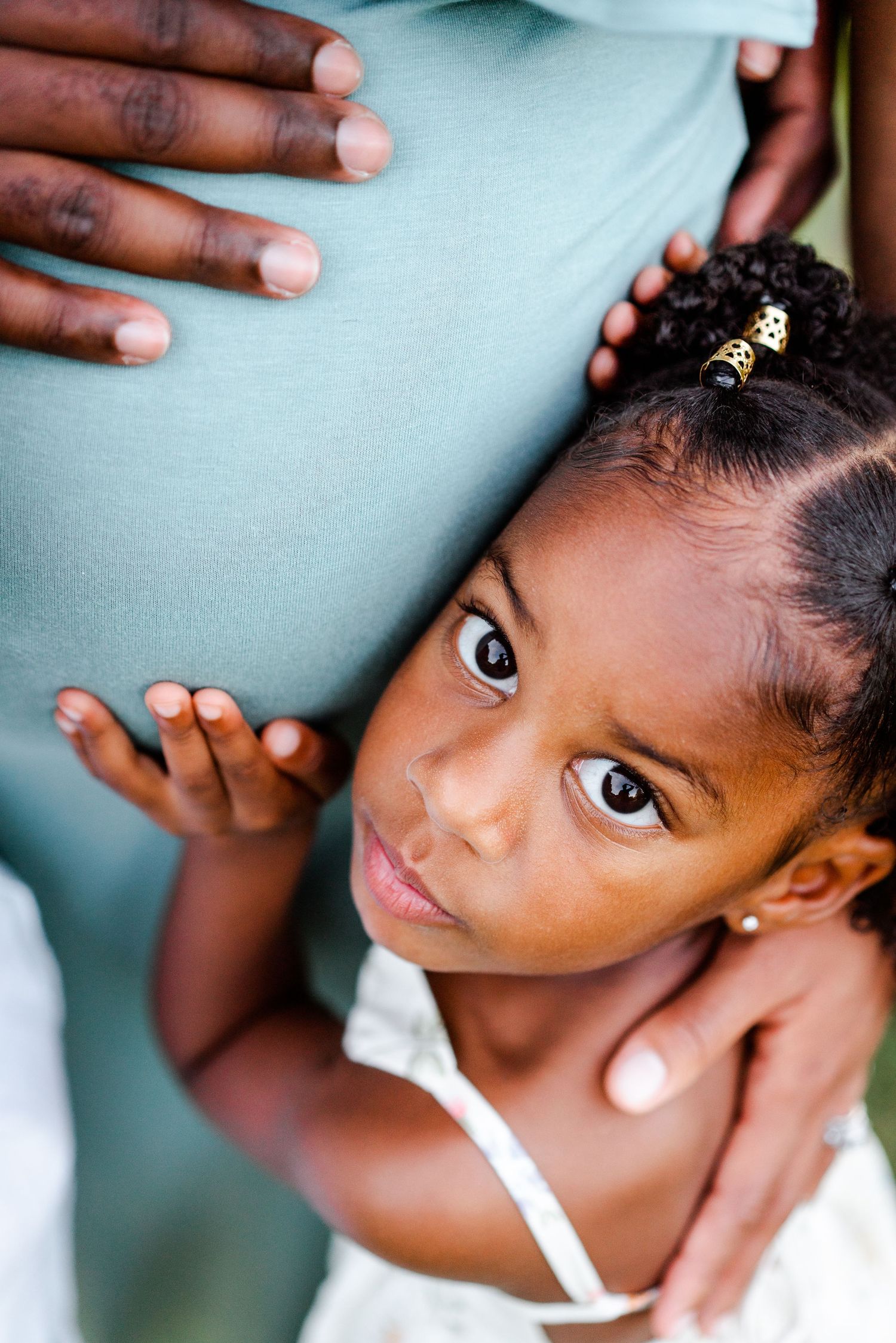 Close-up portrait series showing different angles of a young child's face with soft lighting against a blue background.