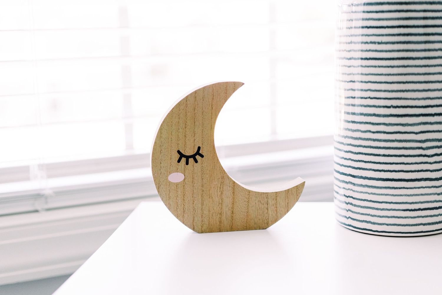 Decorative wooden moon and star nursery wall art in natural wood tones.