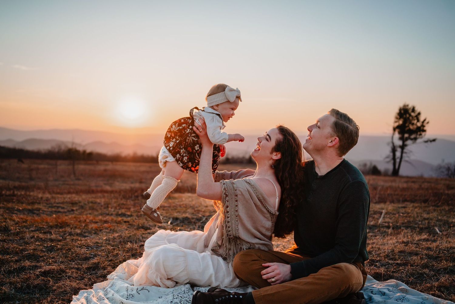 Destination family photography session with parents and children exploring an open mountain valley at sunset.