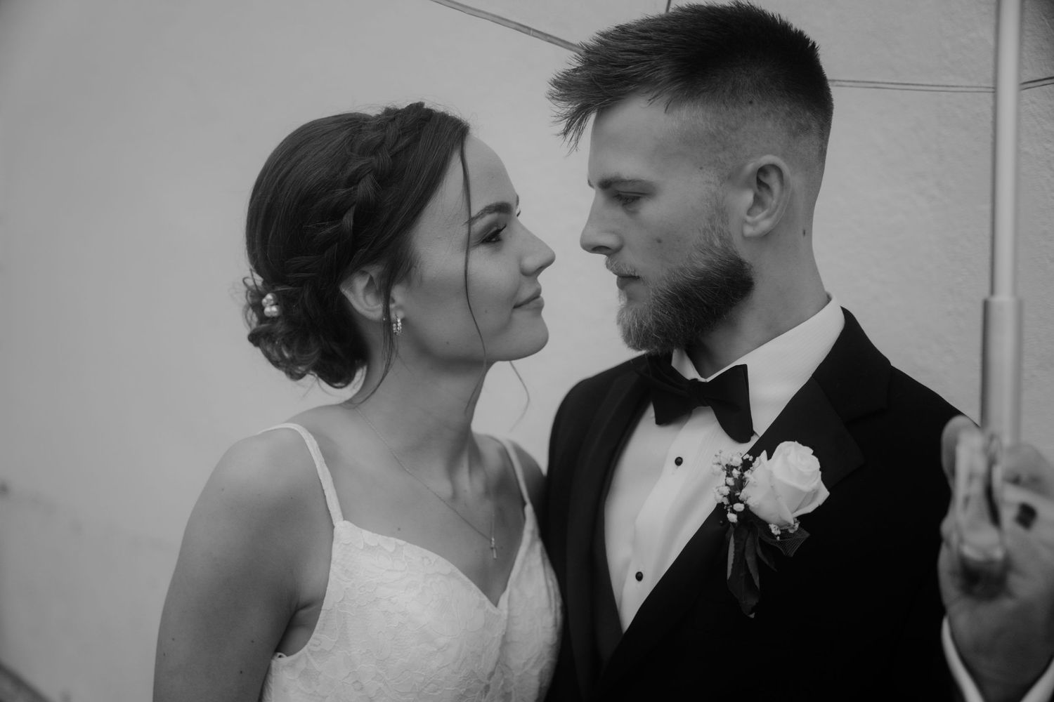 Black and white close-up of bride and groom gazing at each other at wedding reception.