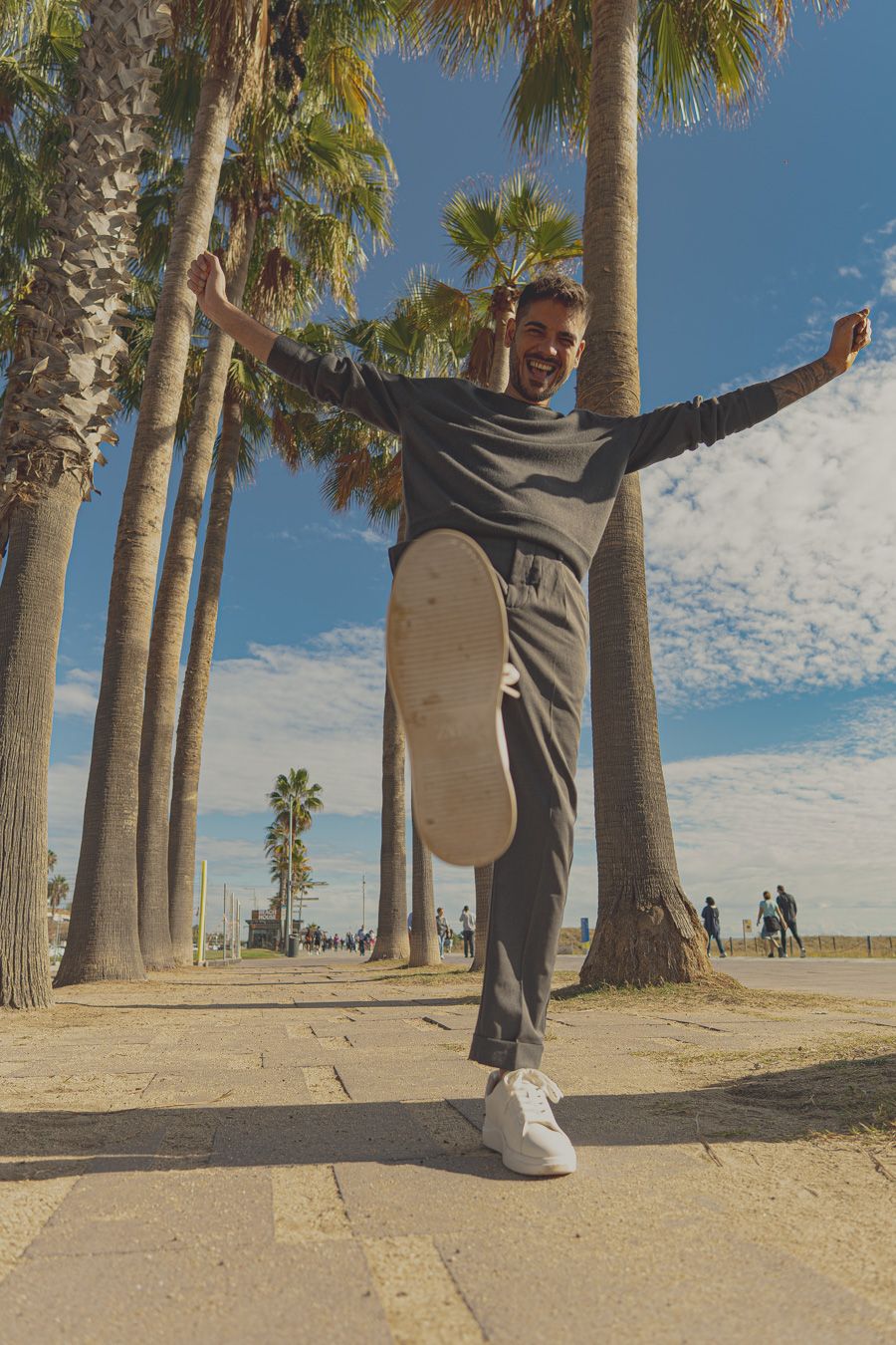 Fotografía de modelo masculino con traje gris en el paseo marítimo en sesión de fotografía con -Meraki by VGracia
