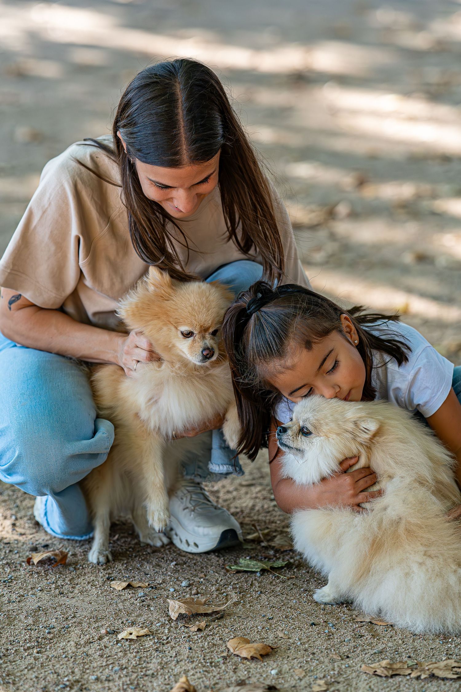 Chica abrazando con ternura a sus perros en el bosque, sesión de fotos lifestyle con mascotas al aire libre en Sant Cugat, Meraki by VGracia