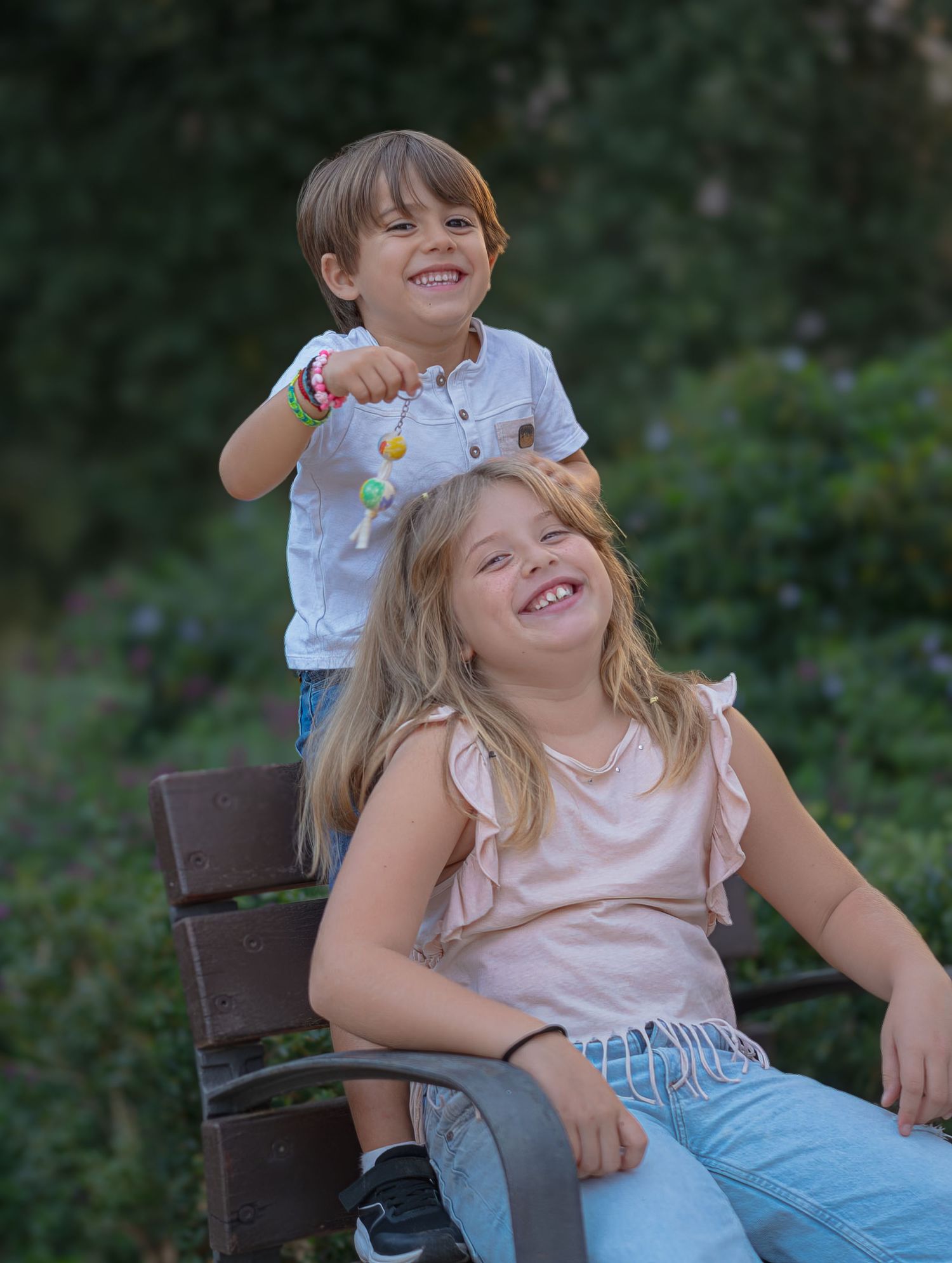 Dos niños riendo a carcajadas sentados en un banco de madera, fotografía de familia lifestyle y divertida en Barcelona, Meraki by VGracia.