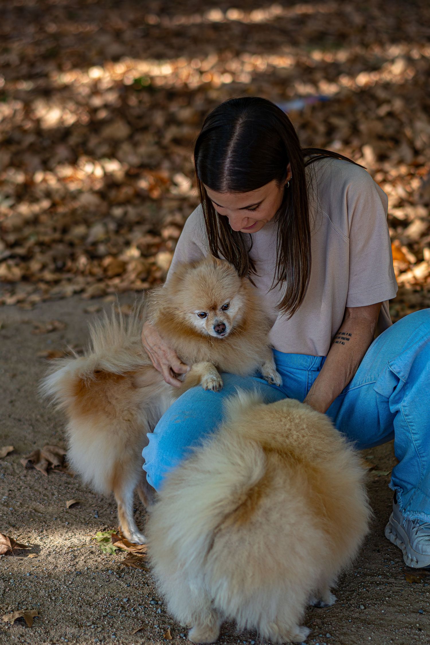Mujer acariciando feliz a sus perros en la naturaleza, reportaje fotográfico familiar con mascotas, fotografía documental Meraki by Vgracia