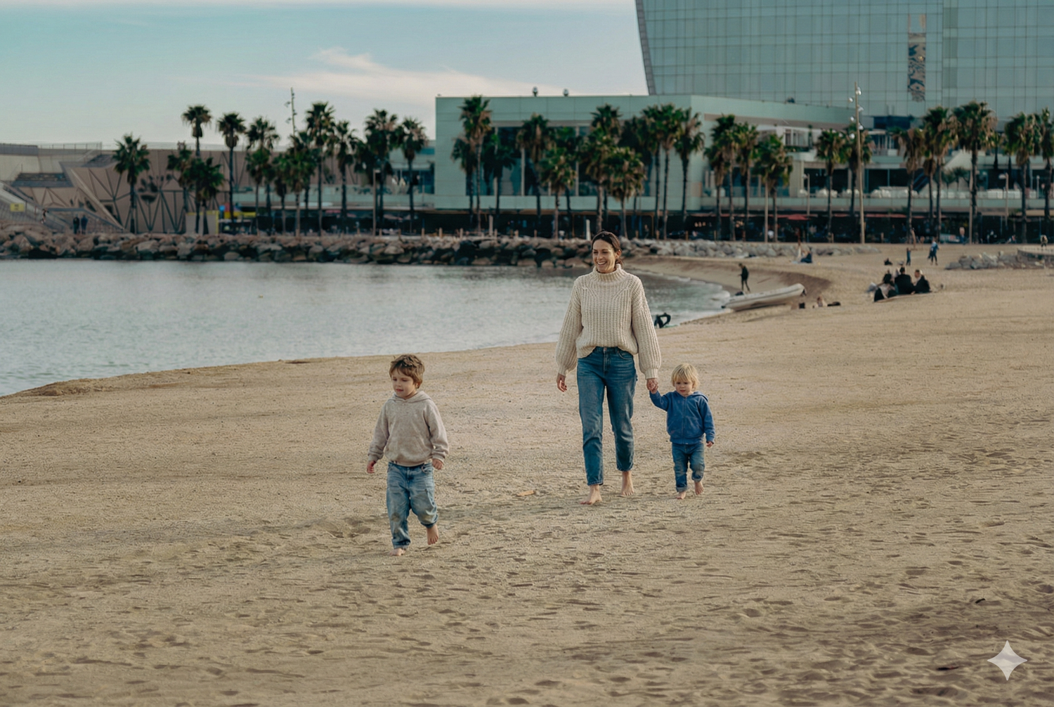 Madre paseando con sus hijos por la playa de Barcelona, sesión de fotos familiar lifestyle al aire libre, fotografía natural Meraki