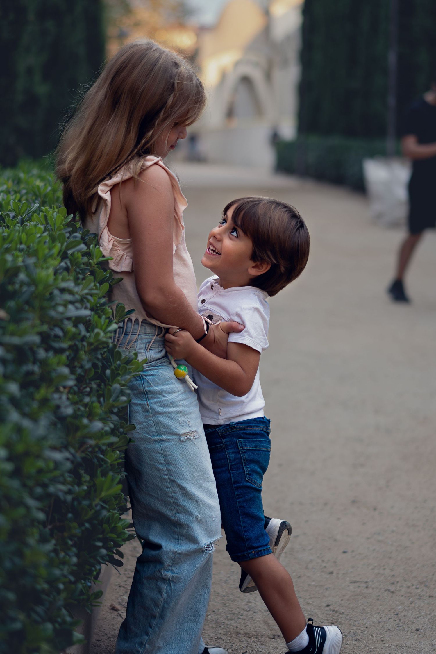 Dos hermanos riendo y jugando juntos en un parque, sesión de fotos infantil natural en exteriores en Sant Cugat, estilo Meraki.