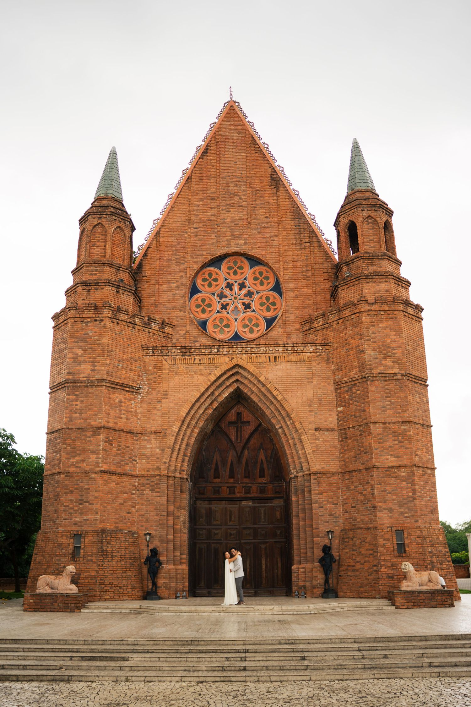 Ornate red brick Gothic church facade with pointed arches and rose windows captured from multiple angles.
