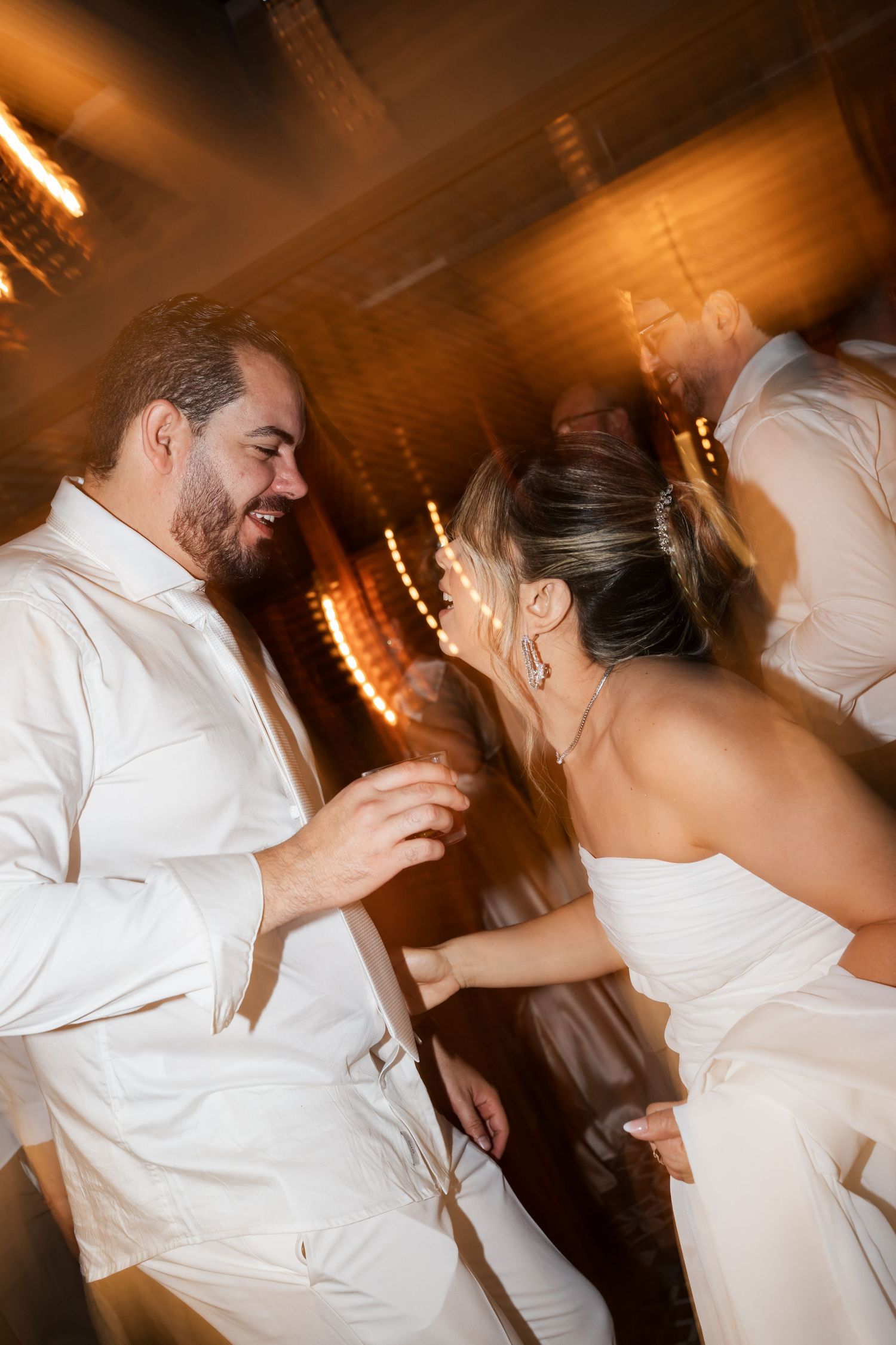 Warm-toned sequence of dance photos showing energetic movement and spins under ambient lighting at a celebration.