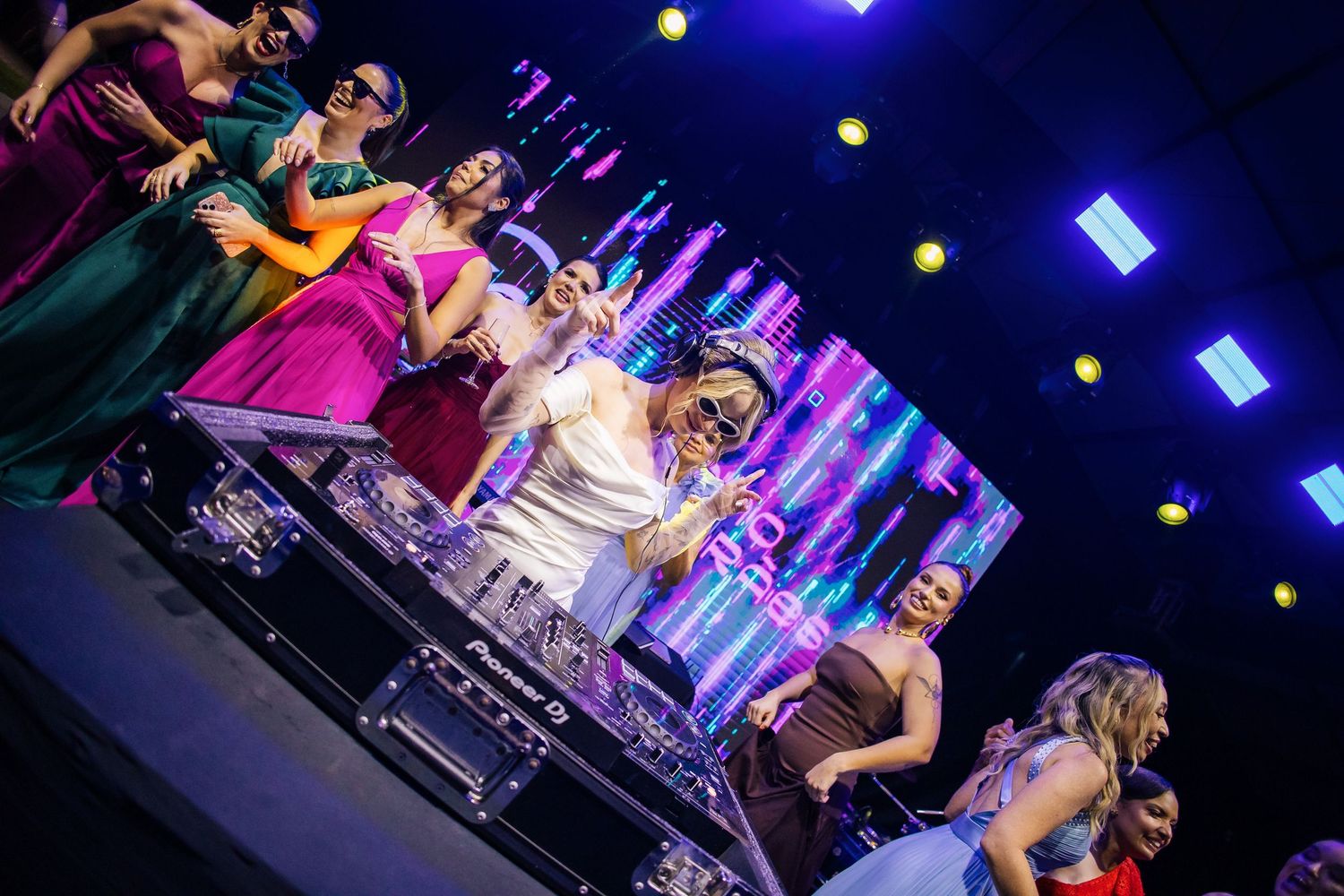 Colorful nightclub scene with vibrant blue and purple lighting during a wedding celebration.