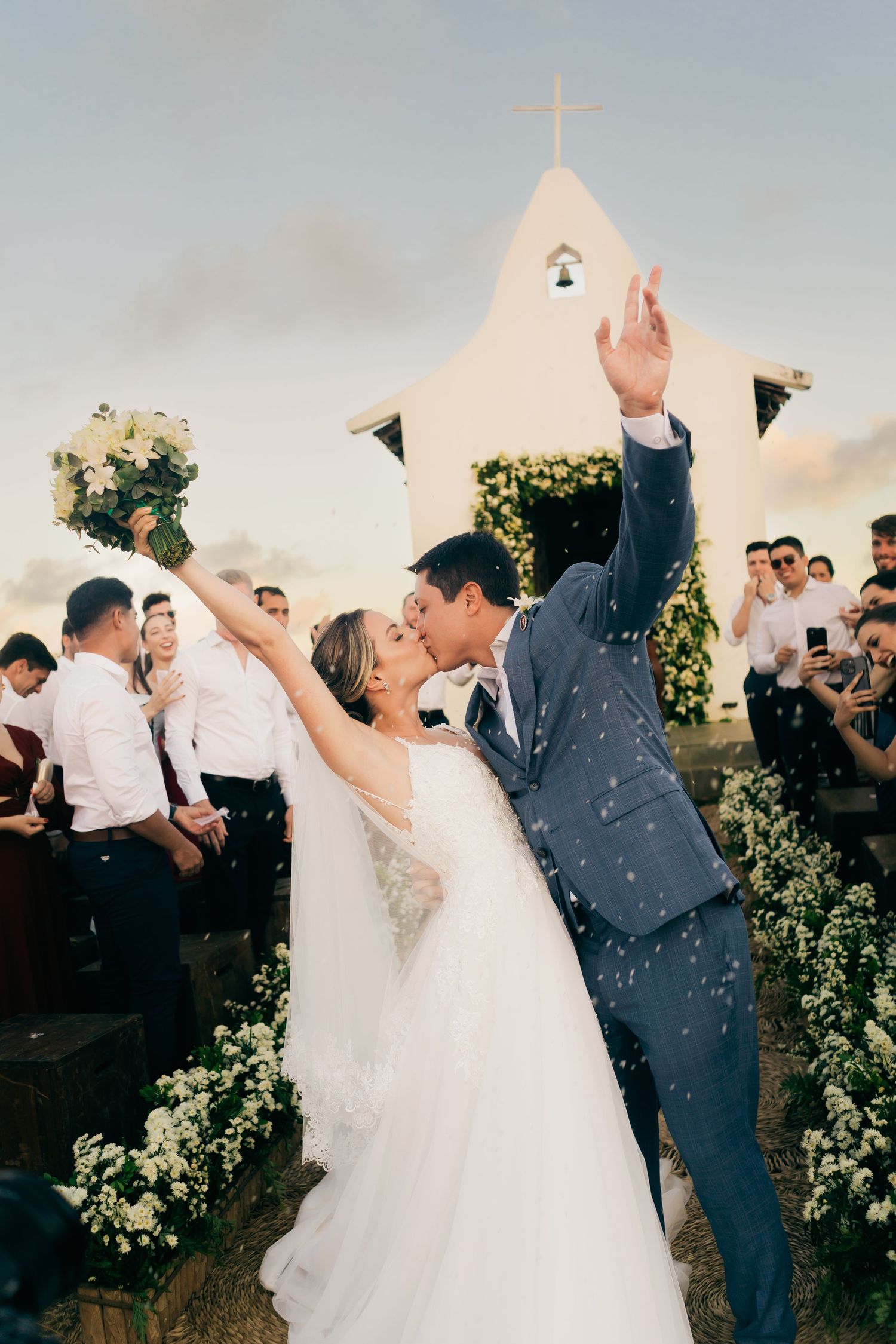 Wedding party celebrates with confetti and sparklers during sunset outdoor reception at vineyard.