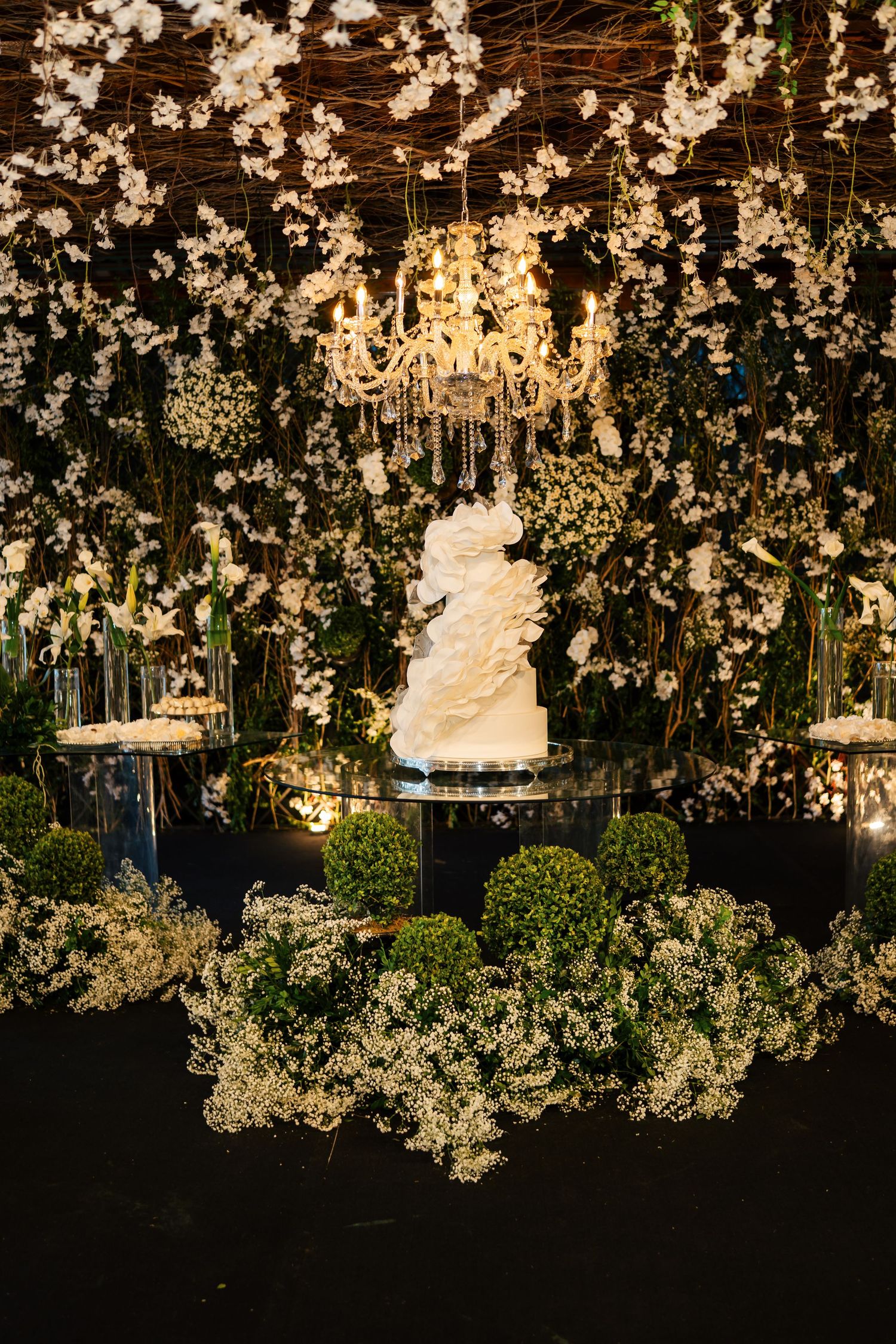 Romantic wedding decor featuring hanging crystal chandeliers and delicate floral arrangements.