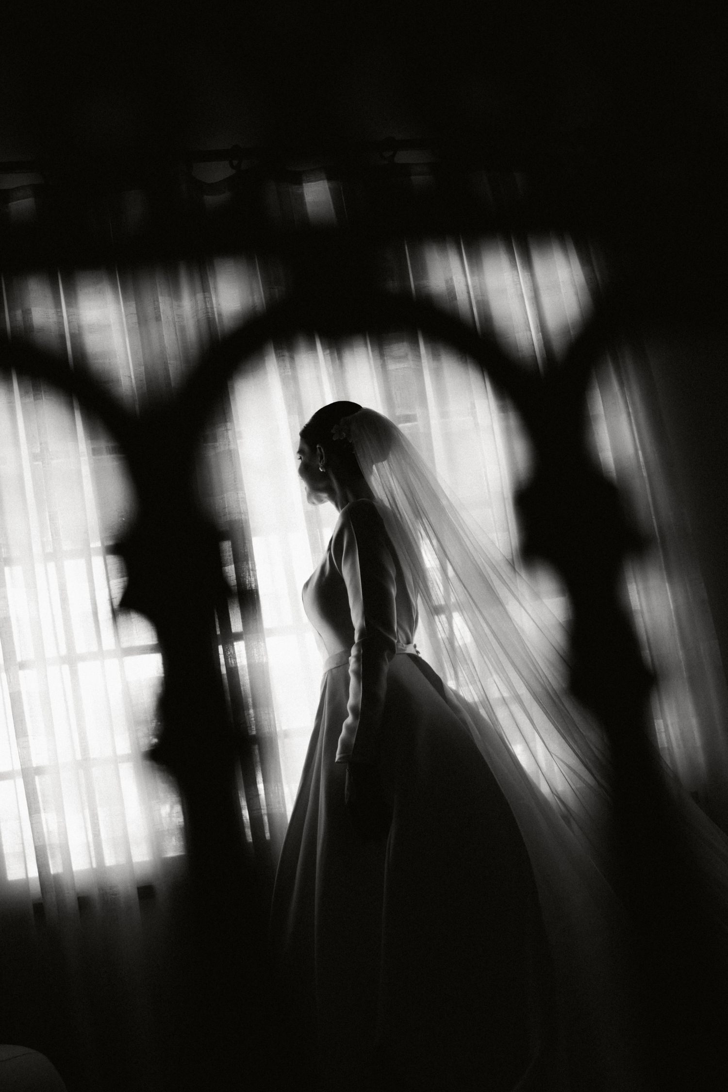 A series of dark silhouettes against bright windows create a moody and dramatic black and white composition.