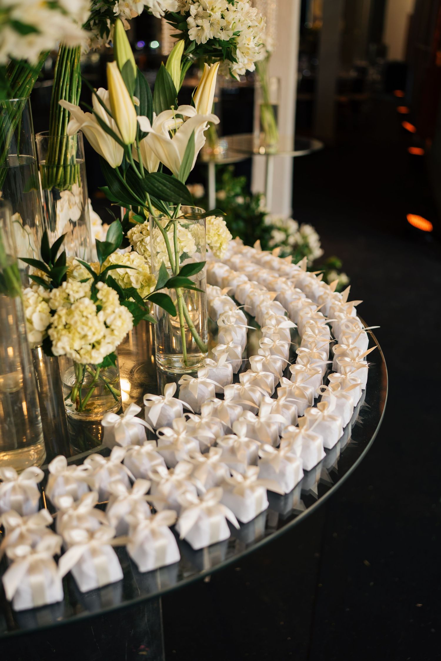Elegant white favor boxes arranged in curved rows with floral decorations.