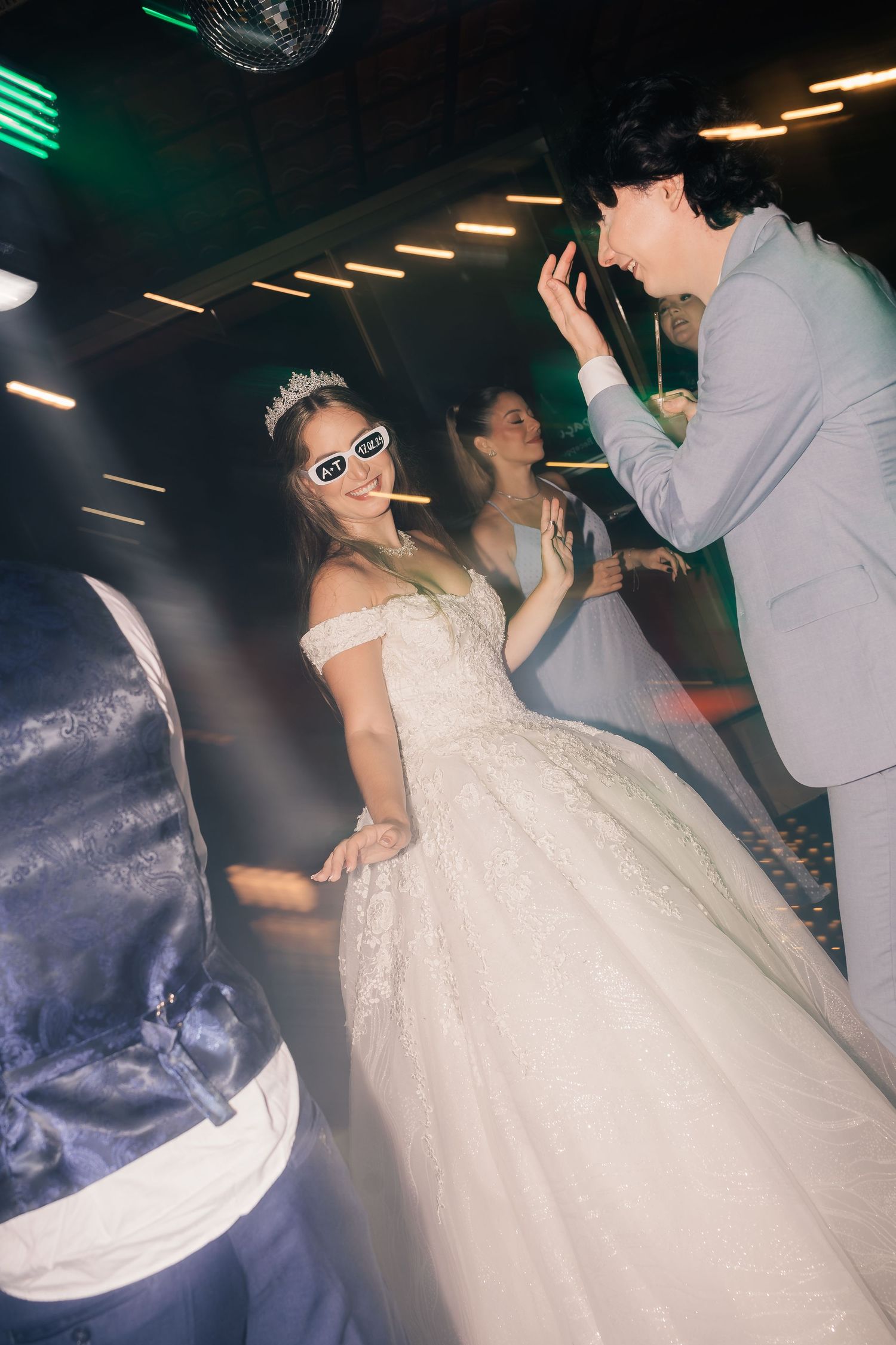 Wedding reception dance party with dramatic lighting and energetic dancing.