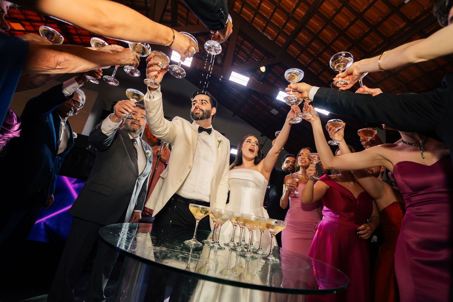 Wedding guests toasting with champagne glasses during a celebratory reception.