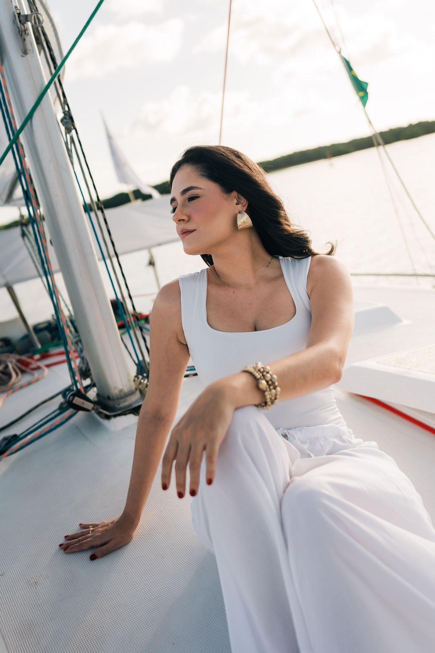A person in white reclines on a white surface in an artistic pose.