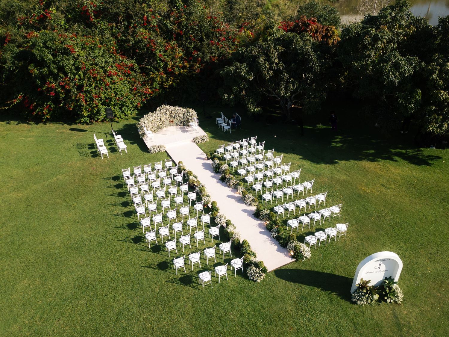 Aerial view of white chairs arranged in rows for an outdoor wedding ceremony.