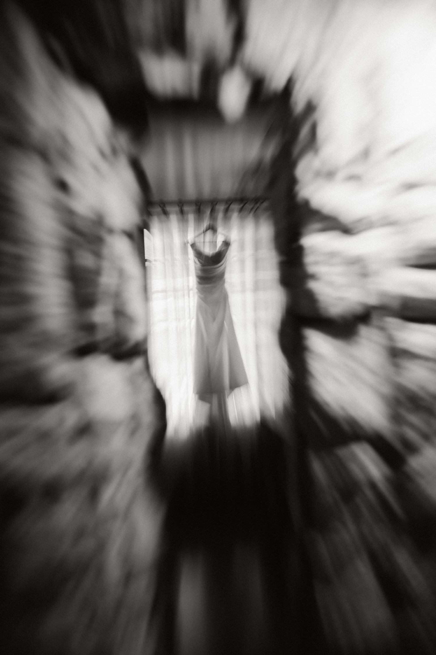 Black and white motion blur photos create an eerie tunnel effect with a ghostly figure at the center of each frame.