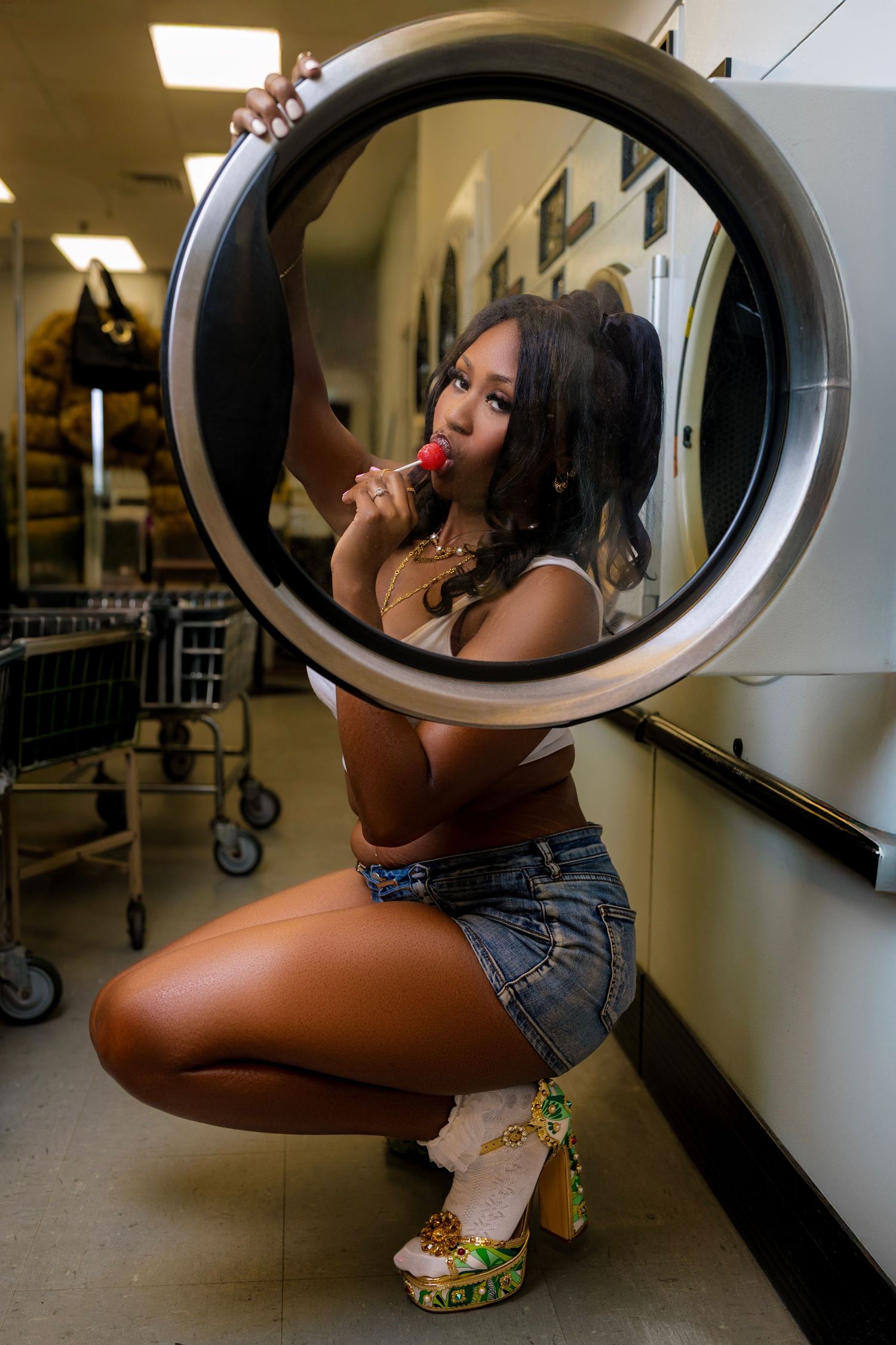 Creative laundromat photoshoot with reflections in washing machine doors.