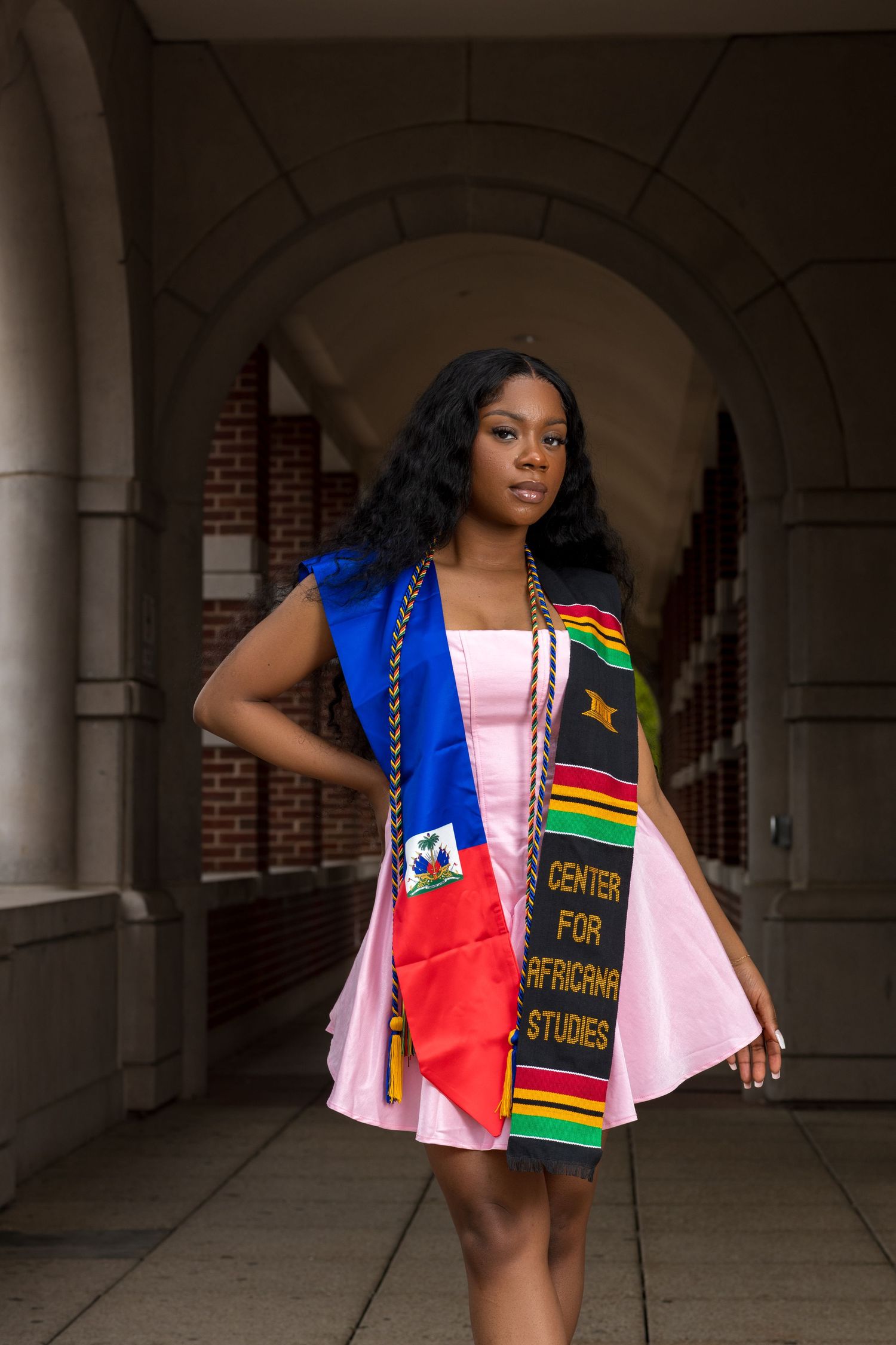 Cultural fashion shoot in an arched hallway featuring flags and traditional textiles.