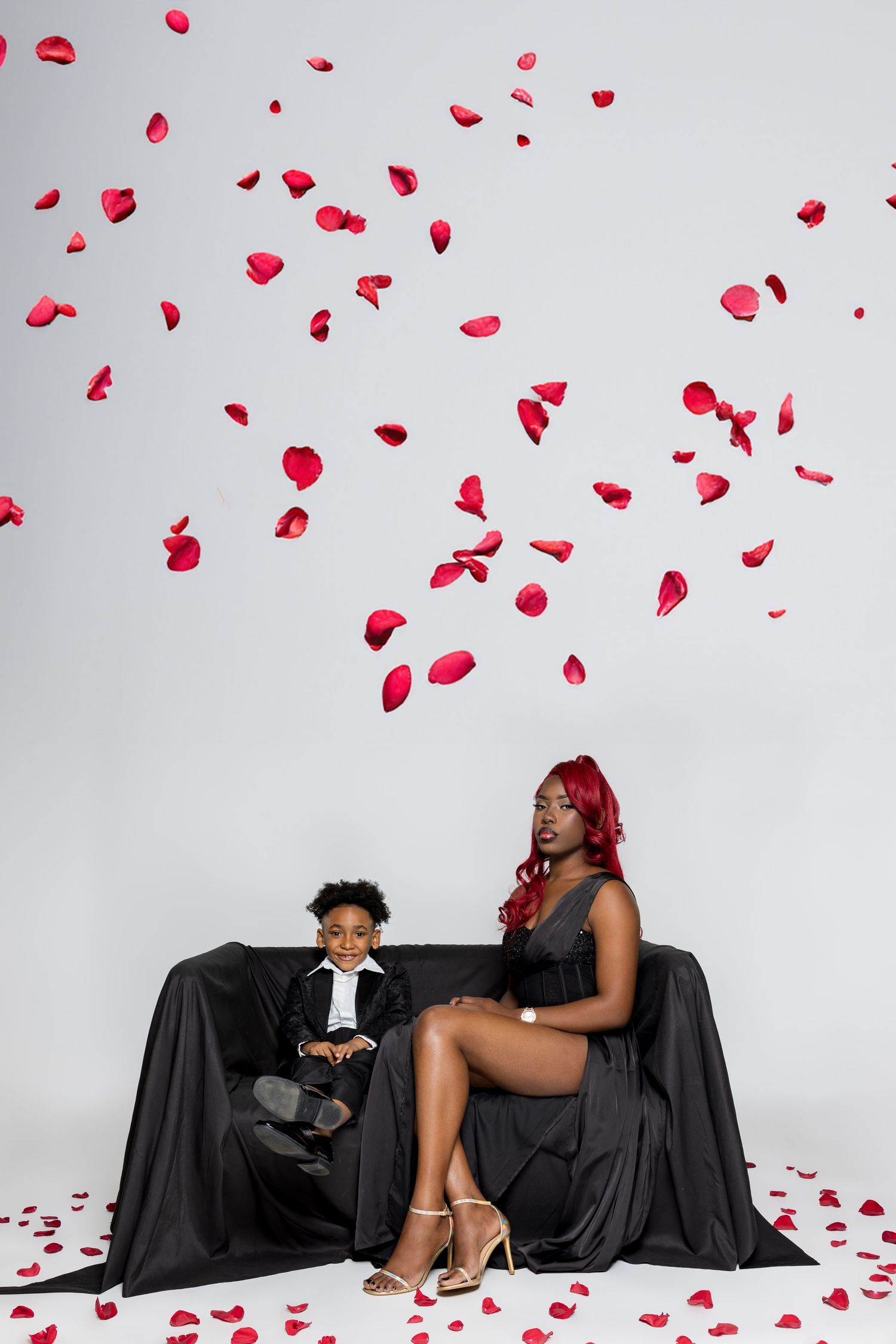 A sequence of romantic photos showing rose petals falling while two people sit on a black couch in an intimate scene.