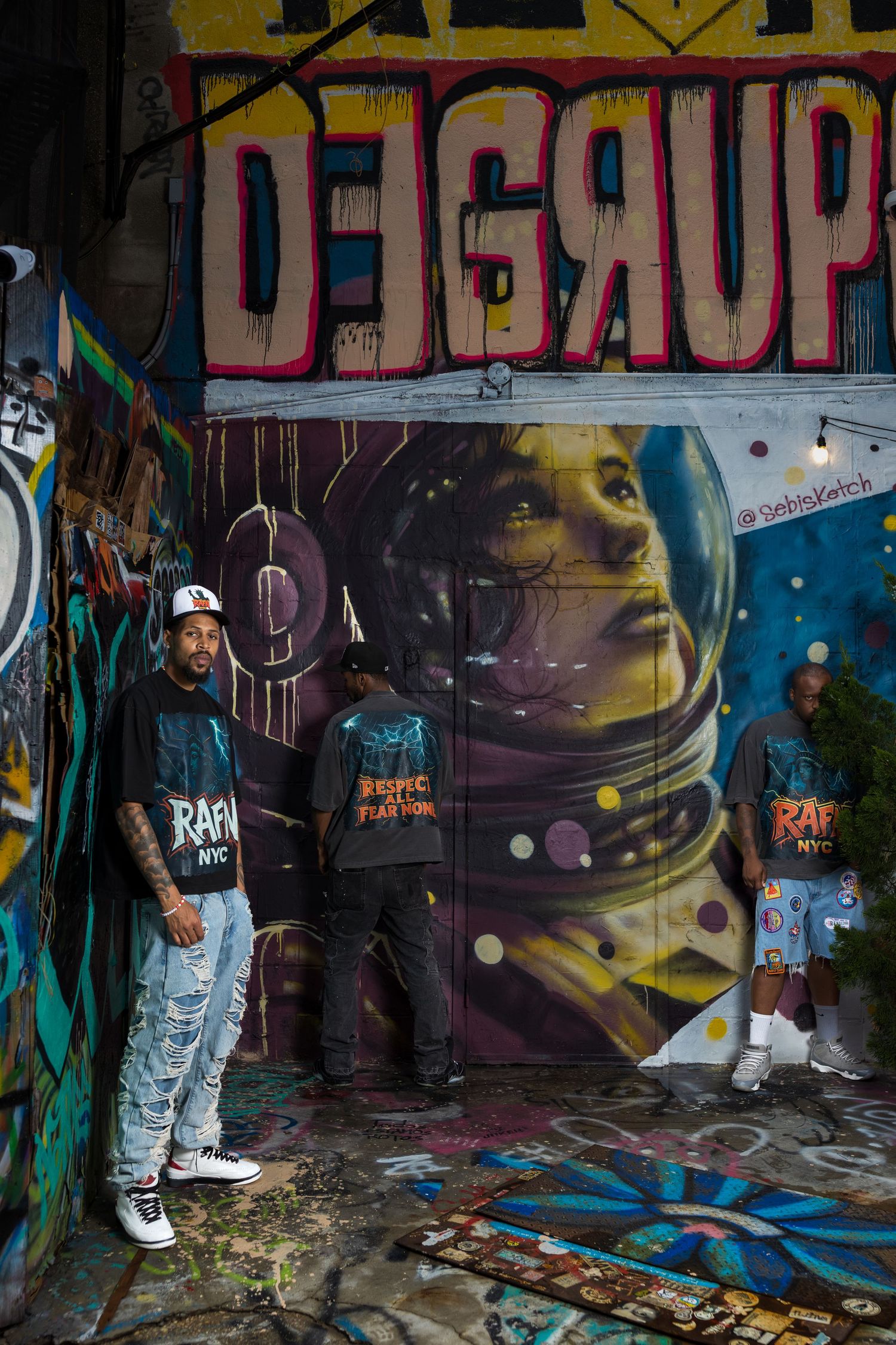 Urban photoshoot with colorful graffiti backdrop featuring street style fashion and sneakers.