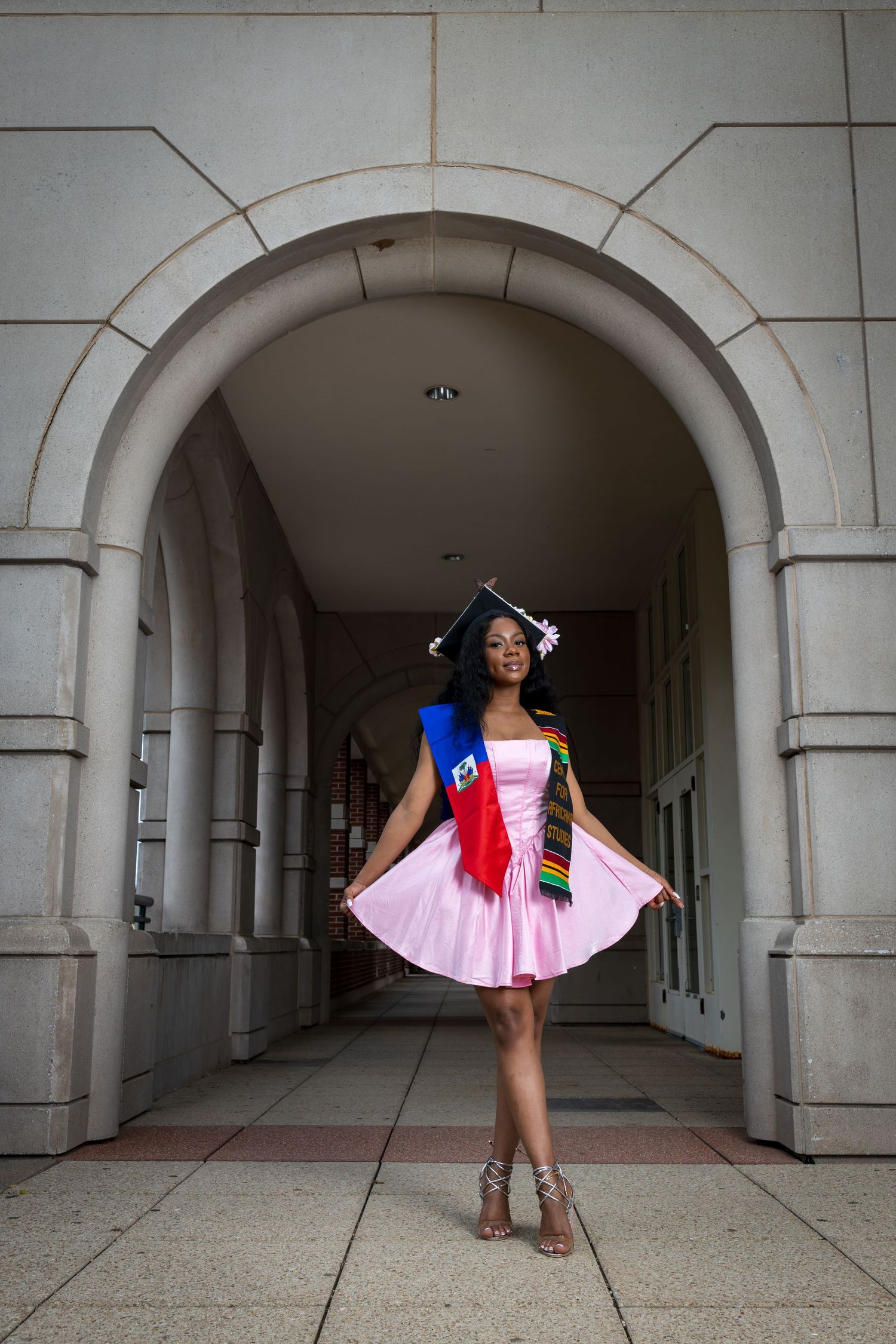 Architectural photoshoot in a white stone colonnade featuring pink and flag-inspired fashion.
