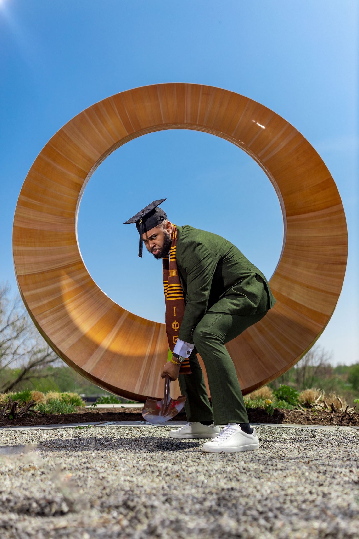 Creative graduation photo series with curved wooden sculpture creating circular framing.