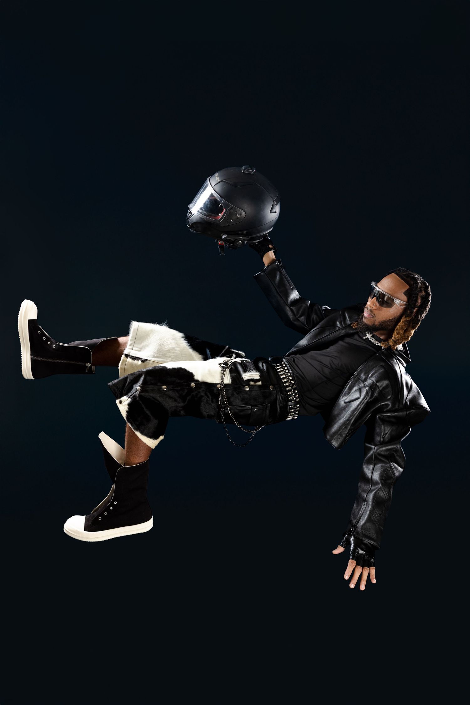 Dynamic action shot of person in black outfit performing martial arts move against dark background.