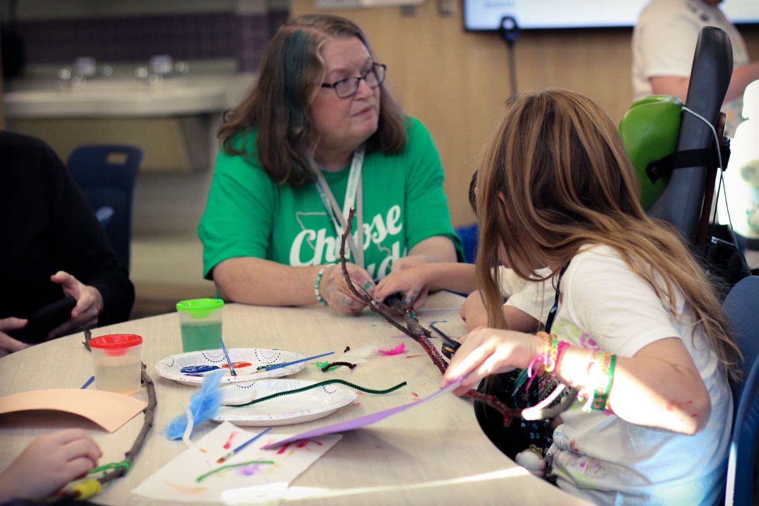 Students work together at tables on an art project.