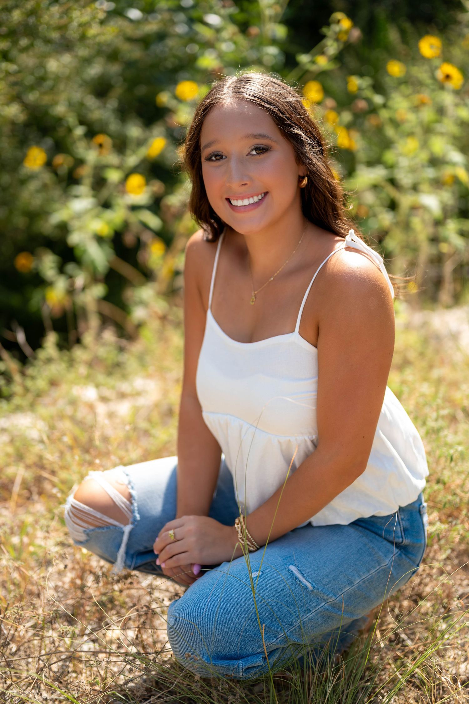 A series of outdoor portrait photos taken in a sunny field with yellow wildflowers and natural lighting. Azle senior photo session.