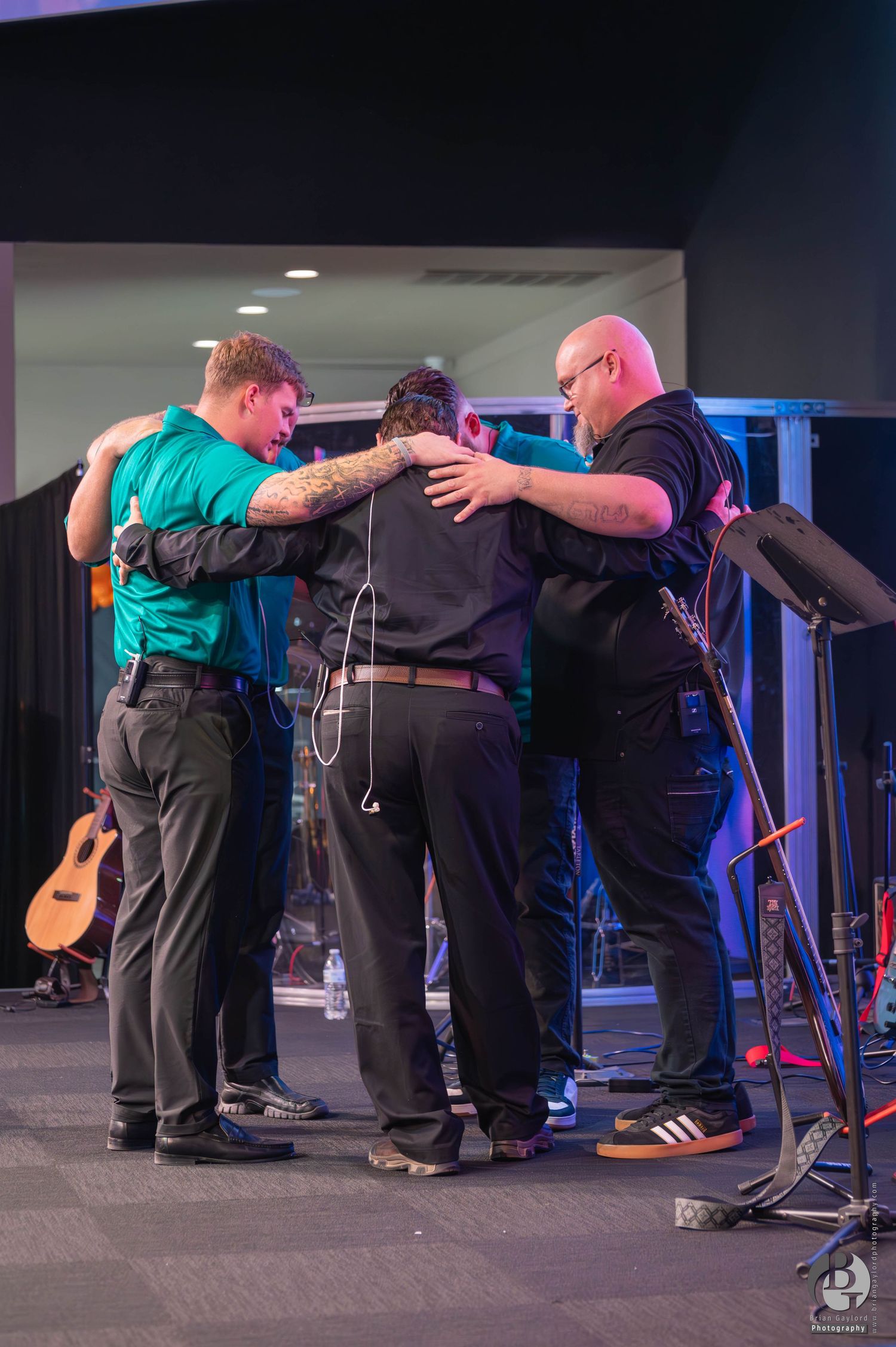 A sequence of images shows people bowing together in synchronized motion on a dimly lit stage. Event Photograph. Adult and teen challenge.