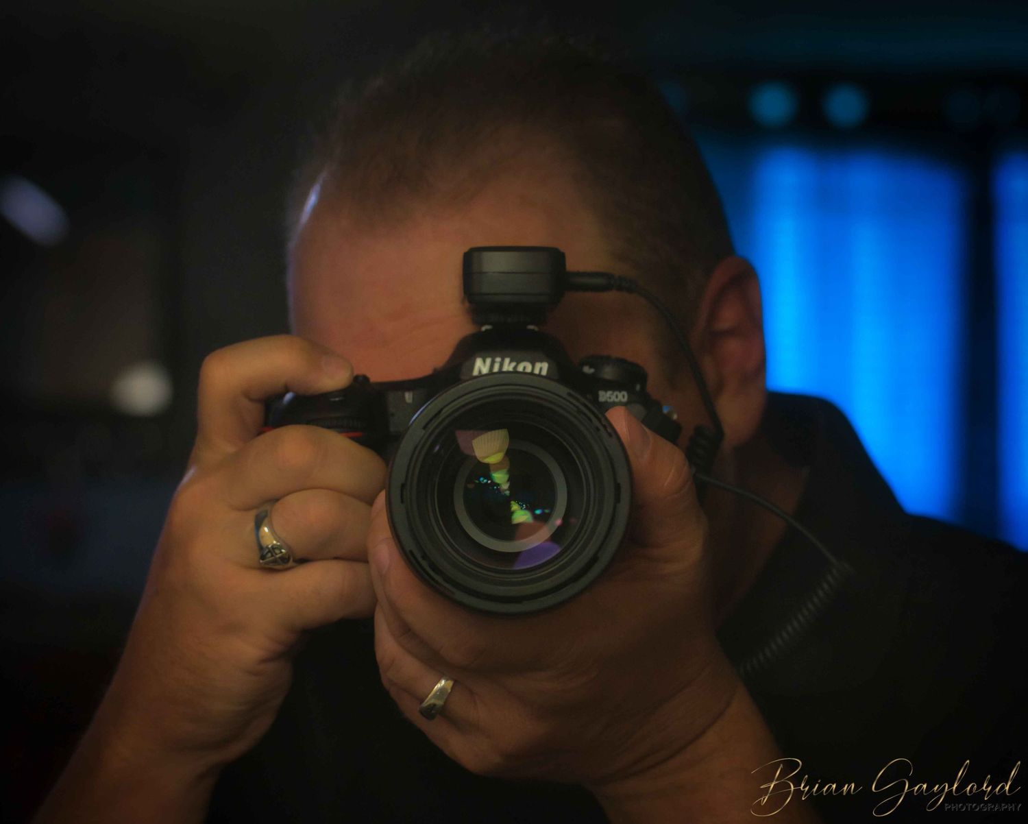 A sequence of camera lenses and photographers in silhouette against a blue background.