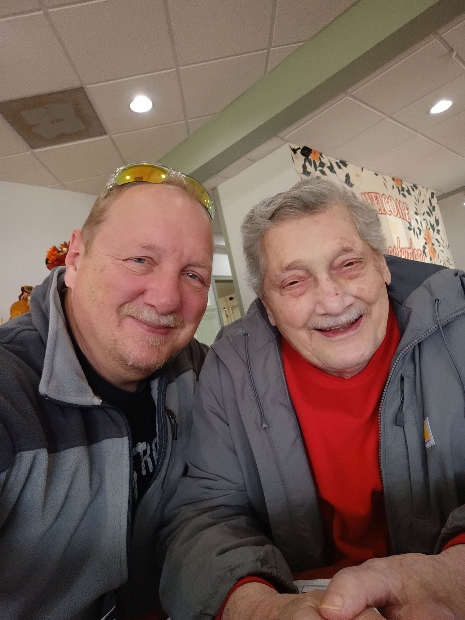 Two people sharing a laugh while sitting together indoors.