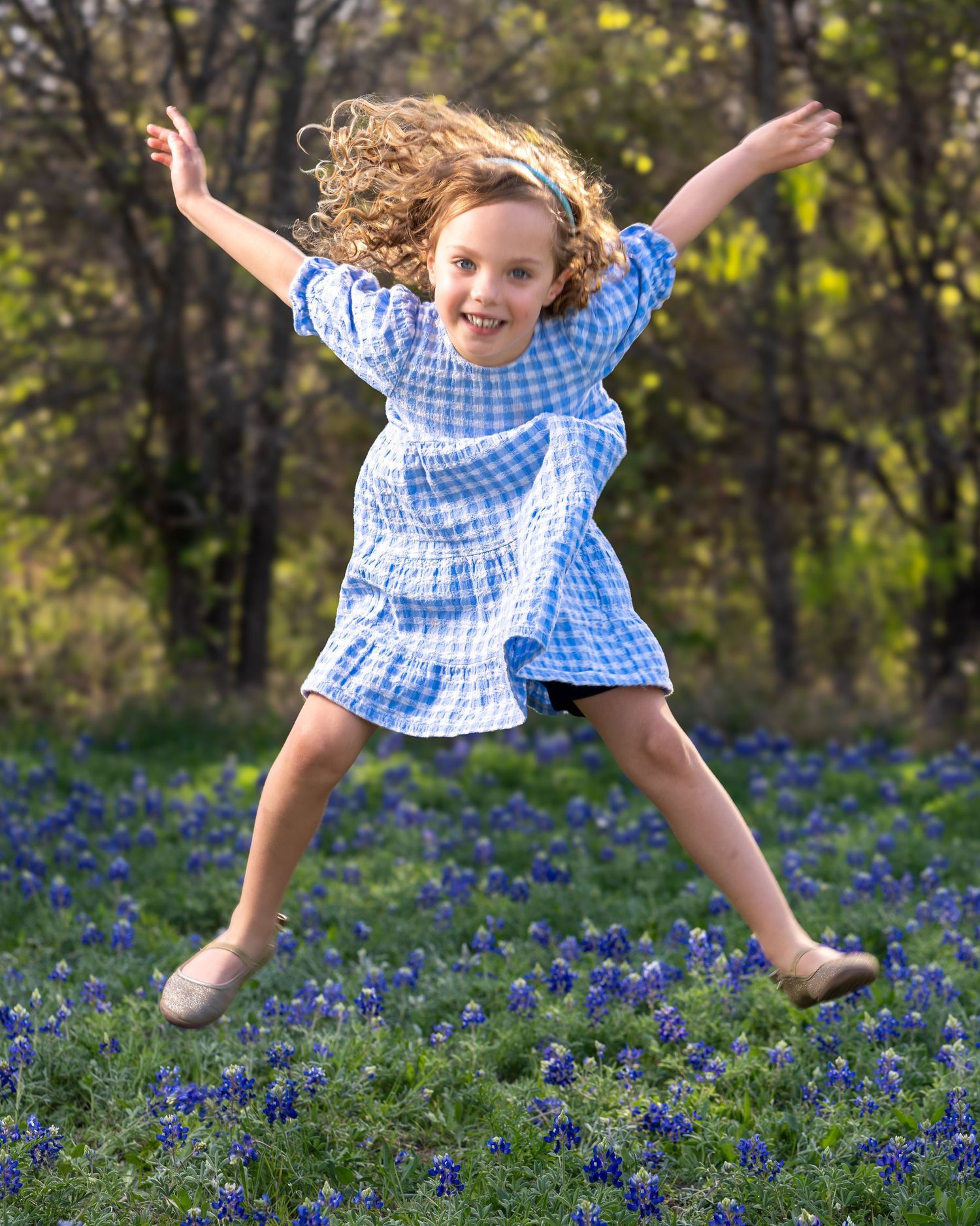 Action sequence showing playful jumping and leaping movements through a field of blooming bluebonnets.
