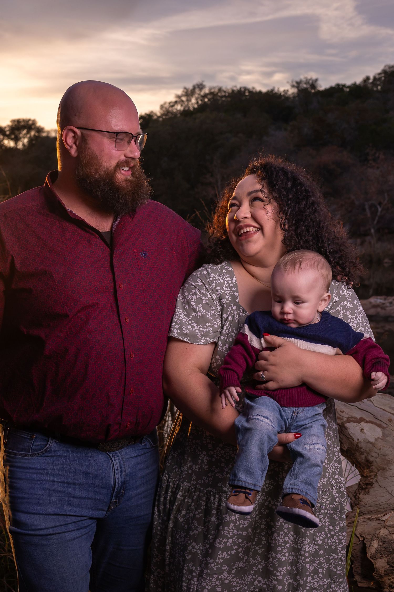 Family enjoying a tender moment together during sunset photo session in nature.