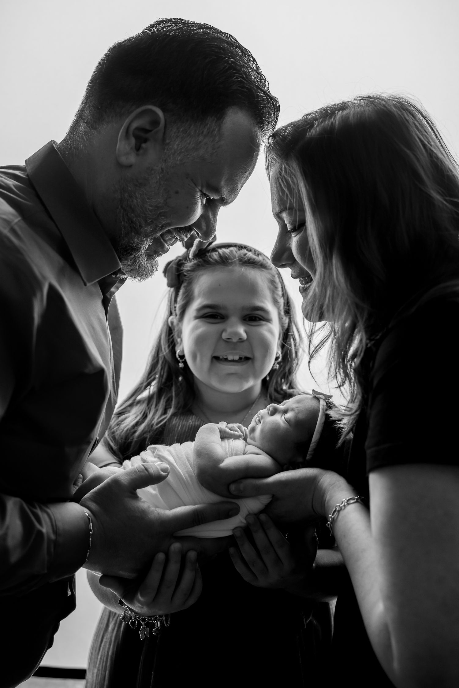 Intimate black and white family portrait showing tender moment of connection and joy.