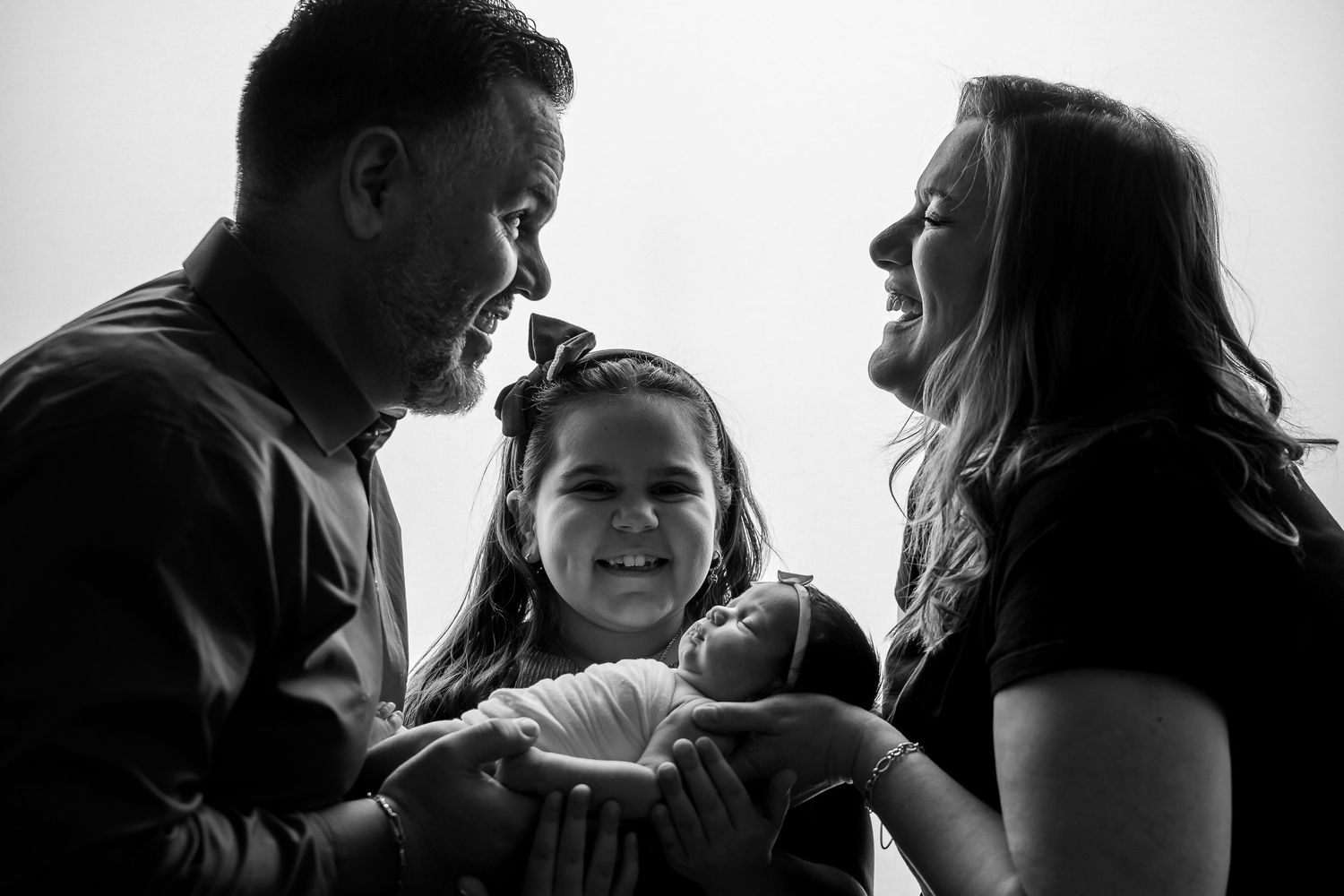 Black and white silhouettes of people interacting in an intimate family moment.