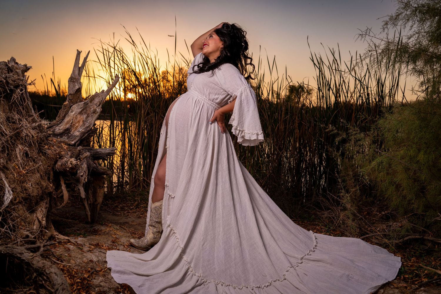 A flowing white dress twirls dramatically against a golden sunset backdrop with desert vegetation silhouetted in the scene.