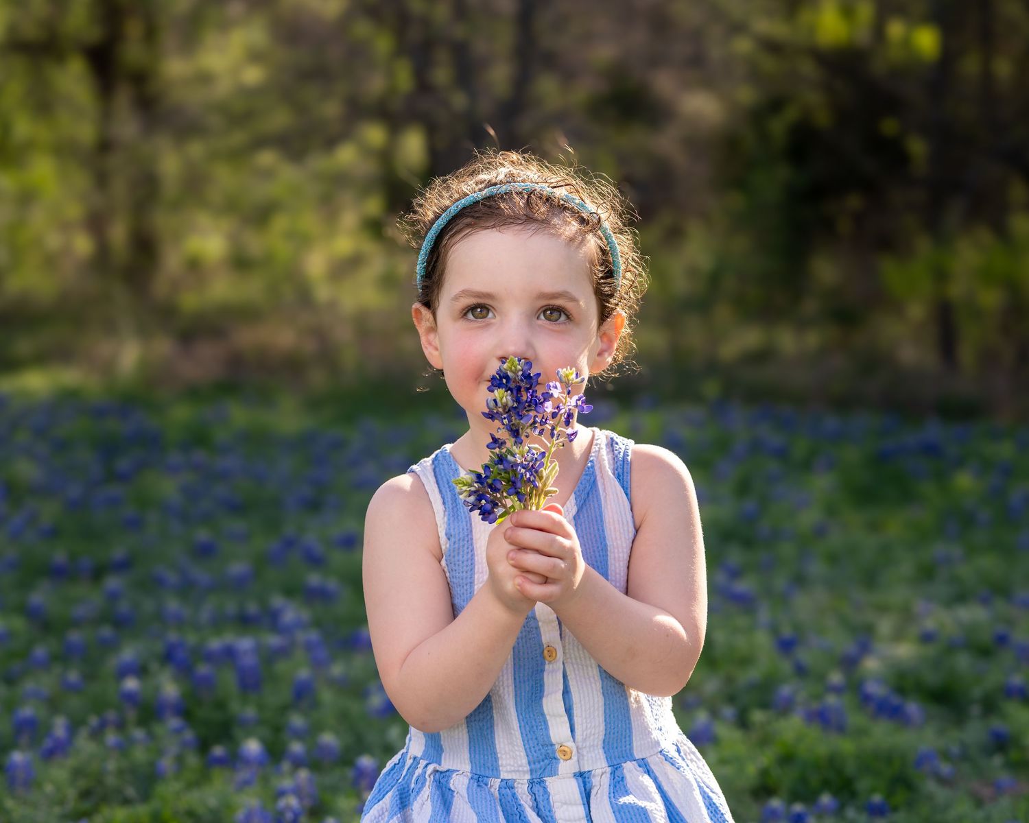 A series of joyful photos in a bluebonnet field showing someone smelling flowers and playing in springtime.