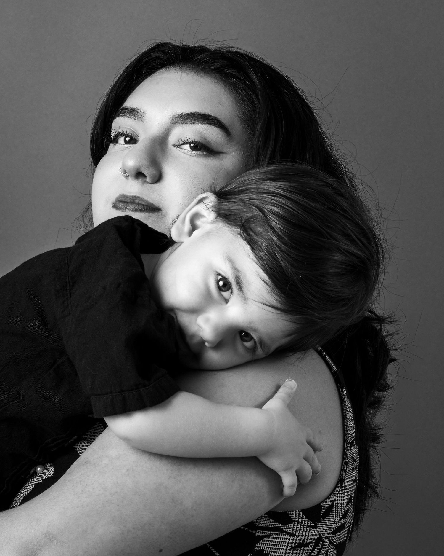Dramatic black and white portrait series showing expressive poses and shadows against dark backgrounds.
